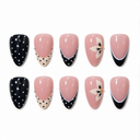 Ten black cream and nude almond nails with polka dots French tips and side flowers on white