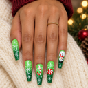Green Christmas coffin nails worn with a gold ring on cream knit beside festive lights