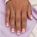Pale lilac French square nails with a silver cross charm worn against lilac linen