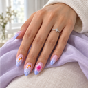 Pink lilac koi and floral almond nails worn with a silver ring against lavender fabric