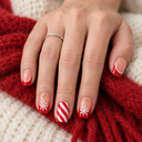 Red French snowflake and candy stripe square press-on nails — worn on hand