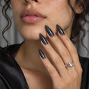 Black silver shimmer stiletto press-on nails — worn on hand