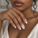 White French pearl and bow almond press-on nails — worn on hand
