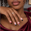Star cherry and eight-ball French almond press-on nails — worn on hand
