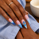 Blue floral ombre shell stiletto press-on nails — worn on hands