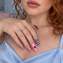 Pink and blue star, stripe and polka dot stiletto press-on nails – model wearing the design