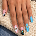 Turquoise marble and cow print coffin nails worn on a hand over an ivory woven bag