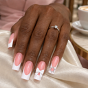 White French bow and crystal star long square nails worn on a hand