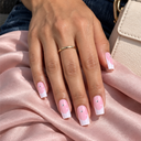 Pink crystal star French square nails on an olive hand over blush silk and denim