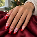 Santa and reindeer red ombre square nails worn on a hand over burgundy fabric