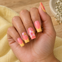 Yellow French floral square press-on nails worn on a softly curled hand above yellow linen